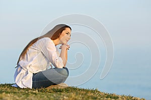 Relaxed woman thinking and looking away on the beach