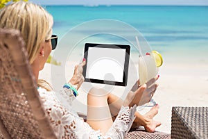 Relaxed woman using tablet computer on the beach
