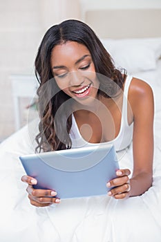 Relaxed woman using tablet pc on bed