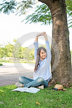 Relaxed Young Beautiful Woman Wear a Blue Shirt With Smiling Face At The Park