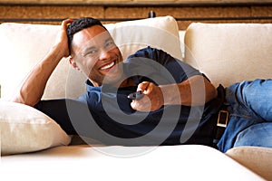 Relaxed young black man watching tv at home