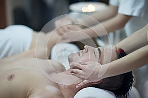 Relaxed young couple getting massage in spa