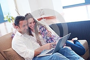 Relaxed young couple working on laptop computer at home