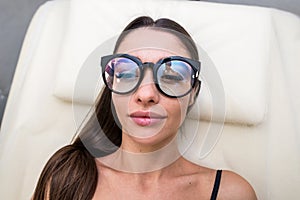 Relaxed young girl is lying on massage table with serenity