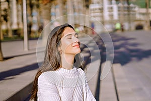 Relaxed young lady in white breathing deep fresh air