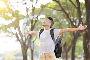 Relaxed young man breathing deeply fresh air in a forest with green trees photo