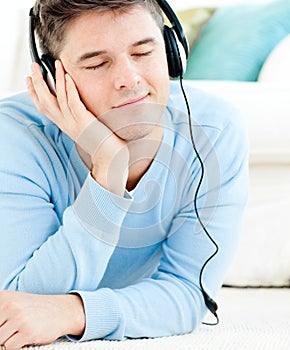 Relaxed young man listen to music with headphones