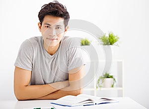 Relaxed young man reading book in living room