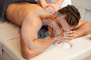 Relaxed young man receiving a back massage