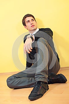 Relaxed young man sitting on the floor