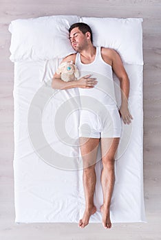 Relaxed young man sleeping on bed
