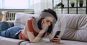 Relaxed young pretty caucasian woman using mobile phone at home.