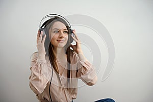 Relaxed young woman enjoying listening to music in wireless earphones, stress free meditation concept. Girl taking a