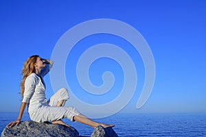 Relaxed young woman enjoying sunset by the sea