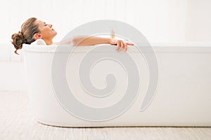 Relaxed young woman laying in bathtub