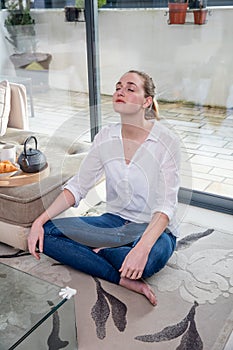 Relaxed young woman leaning back for morning yoga and meditation