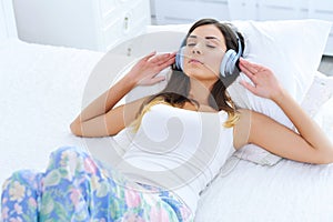 Relajado mujer joven escuchando sobre el música en auriculares 