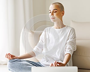 Relaxed young woman meditating on floor at home