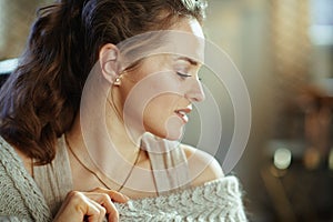 Relaxed young woman in modern living room in sunny autumn day