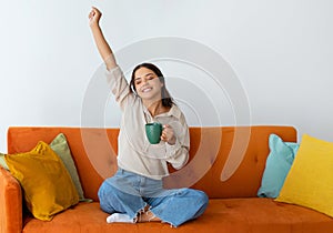 Relaxed Young Woman With Mug Of Tea Relaxing On Couch At Home
