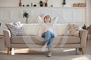 Relaxed young woman rest on sofa in living room