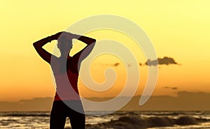 Relaxed young woman standing in sports gear on seacoast