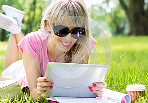 Relaxed young woman using tablet computer outdoors