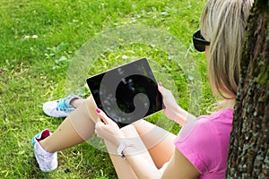 Relaxed young woman using tablet computer outdoors