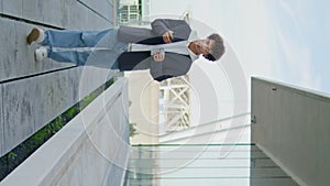 Relaxed youngster walk city in glass reflection vertical. Student holding coffee