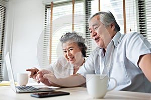 Relaxing Asian Senior couple making video call and talking with family on Laptop computer. Happy Smiling Japanese Elderly man and