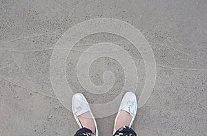 Relaxing background Woman's leg white shoes shot- Light grey Baltic sand