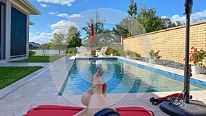 A relaxing backyard swimming pool with red umbrellas