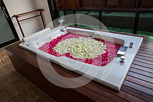 A relaxing bath with rose. bath tub with floating petals. Rose petals put in bathtub for romantic bathroom in honeymoon suit.