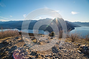 Relaxing bench facing Iseo Lake and mountains hit by the sun light