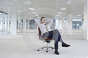 Relaxing Businessman On Chair In New Office