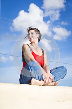 Relaxing Caucasian Brunette Female Girl in Street Colorful Clothing Posing Outdoors While Sitted On Fence Outdoors At Sunny Day