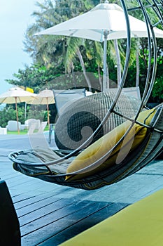 Relaxing chairs with pillows beside swimming pool