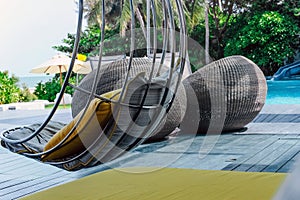 Relaxing chairs with pillows beside swimming pool