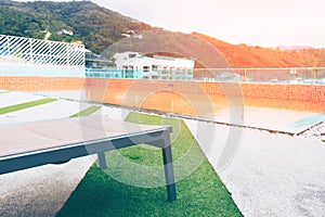 Relaxing chairs with beside swimming pool on top deck hotel.