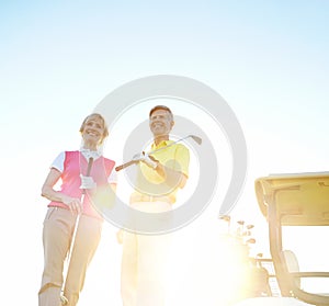 Relaxing end to the day. Attractive elderly couple on the green with the sun setting behind them.