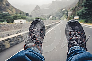 Relaxing feet with trekking footwear hanging from pickup car after long trek way. Santo Antao Island, Cape Verde