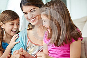 Relaxing and in great spirits. A young mother spending some quality time with her two daughters.