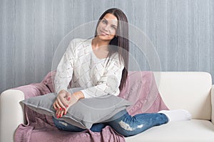 Relaxing at home, comfort. cute young woman smiling, relaxing on white couch, sofa at home