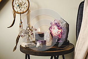 Relaxing home shrine with relaxing objects  amethyst cluster geode lamp illuminated.