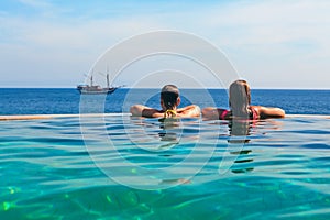 Relaxing in infinity swimming pool with sea view