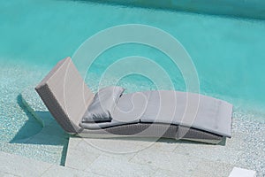Relaxing or Leisure rattan chair bed in swimming pool with blue sky and cloud
