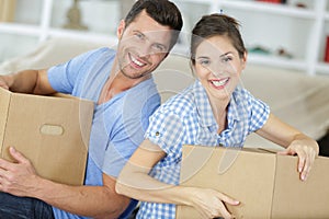 relaxing loving couple embracing with card boxes smiling at camera photo
