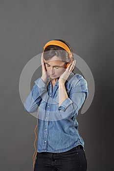 Relaxing middle aged woman standing with eyes closed enjoying peace