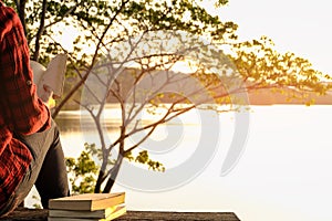 Relaxing moments, Young woman reading a book in nature background. Solo relaxation, color of Hipster Tone.