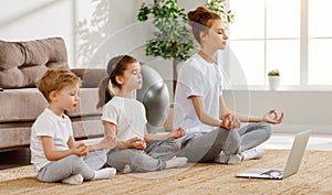 Relaxing mother with children meditating at home